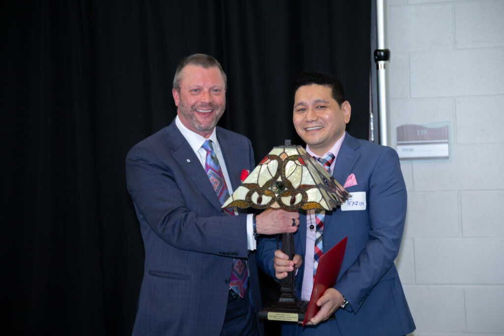 Professor Tenzin Dadul receives the 2022 Agere ex Missione faculty award from President Taylor.