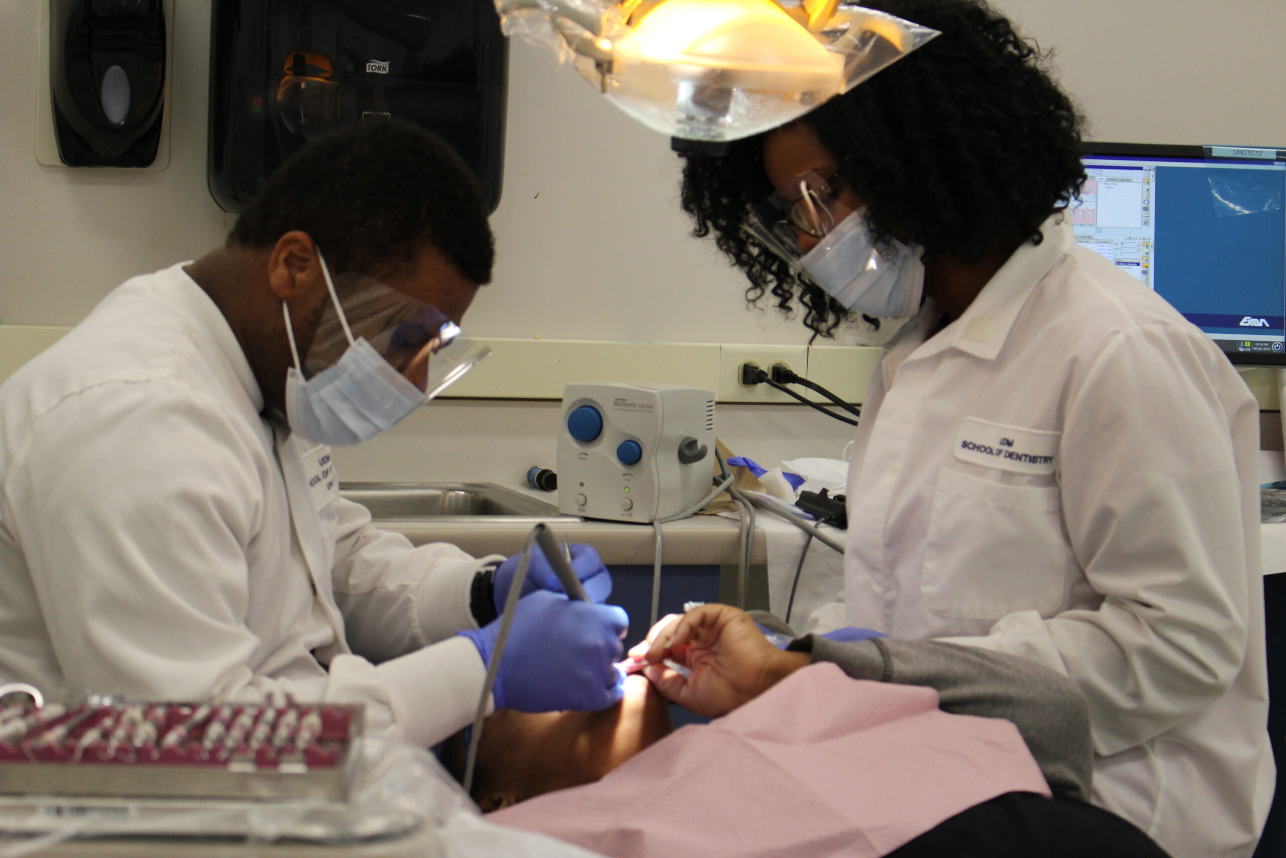 two dental students practicing on a dummy