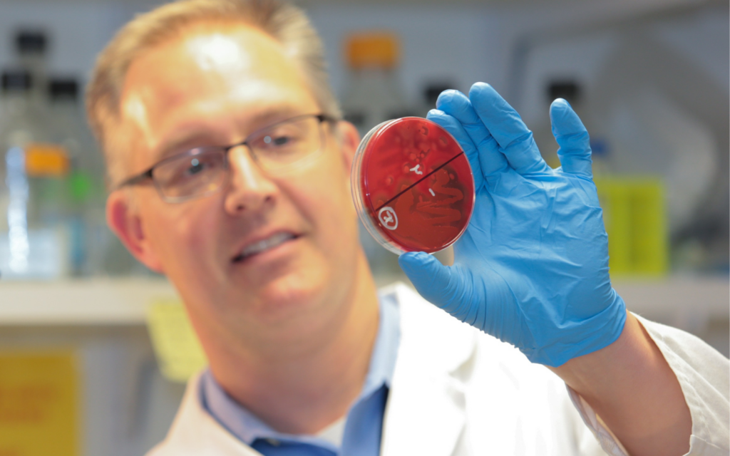 Dr. Eric Krukonis looking at a petri dish.