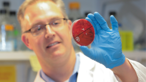Dr. Eric Krukonis looking at a petri dish.